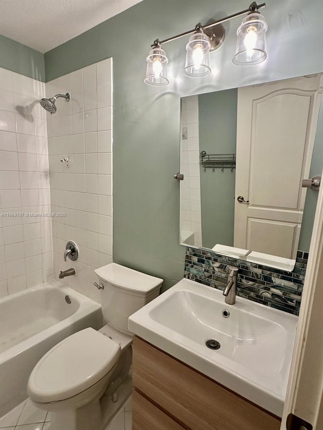 full bathroom featuring tiled shower / bath, tasteful backsplash, vanity, toilet, and a textured ceiling