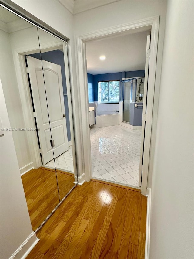 hall with crown molding and light hardwood / wood-style floors