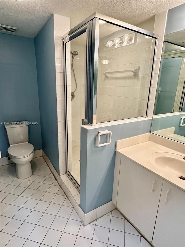 bathroom with vanity, tile patterned floors, a textured ceiling, and a shower with shower door