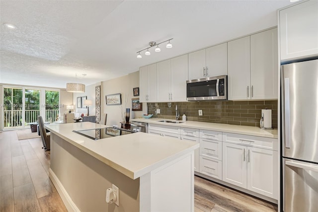 kitchen featuring white cabinets, stainless steel appliances, and light hardwood / wood-style flooring