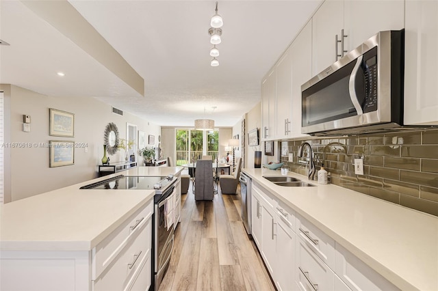 kitchen featuring appliances with stainless steel finishes, sink, and white cabinets