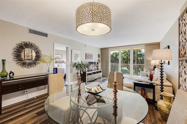 dining area featuring a textured ceiling and dark hardwood / wood-style flooring