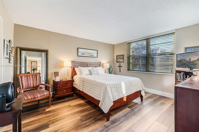 bedroom featuring a textured ceiling and hardwood / wood-style floors