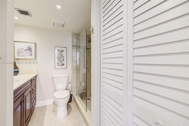 bathroom featuring walk in shower, vanity, toilet, and tile patterned floors