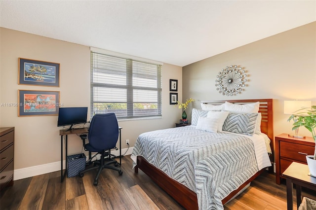 bedroom with a baseboard radiator and dark hardwood / wood-style floors