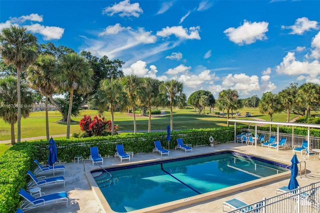 view of swimming pool featuring a patio and a yard