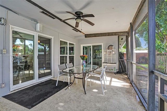 unfurnished sunroom featuring ceiling fan and a wealth of natural light