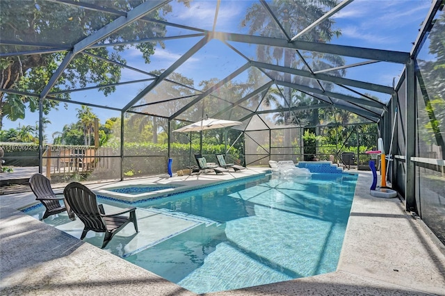 view of pool featuring glass enclosure, a jacuzzi, and a patio