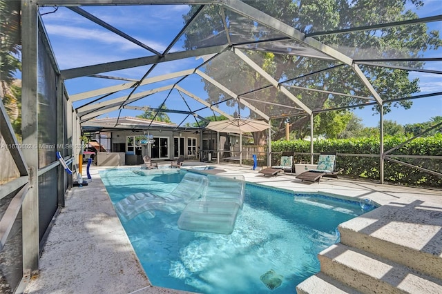 view of pool with glass enclosure and a patio