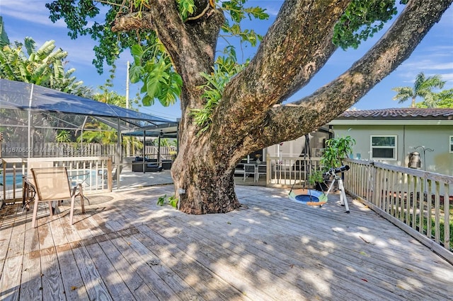 wooden terrace with a lanai and a pool