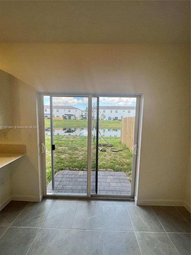 entryway with a water view and tile patterned floors