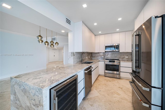 kitchen featuring white cabinetry, stainless steel appliances, tasteful backsplash, wine cooler, and decorative light fixtures