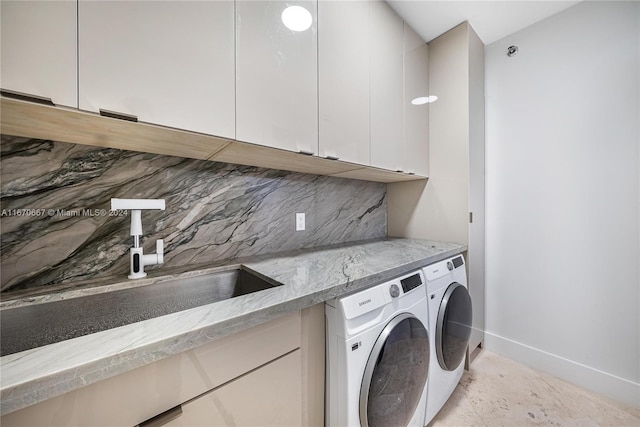 washroom featuring cabinets, washing machine and dryer, and sink