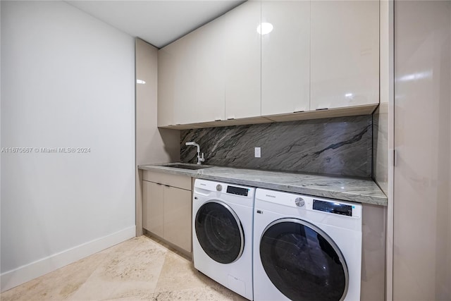 laundry area featuring cabinets, independent washer and dryer, and sink