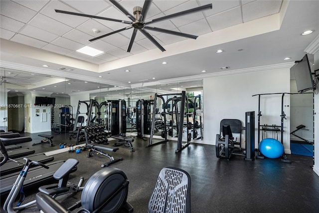 gym with a drop ceiling, ceiling fan, and crown molding