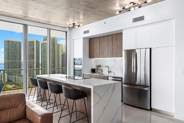 kitchen featuring a kitchen breakfast bar, stainless steel appliances, a wealth of natural light, and a kitchen island