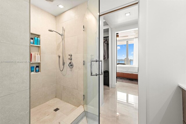 bathroom with walk in shower, vanity, and tile patterned flooring