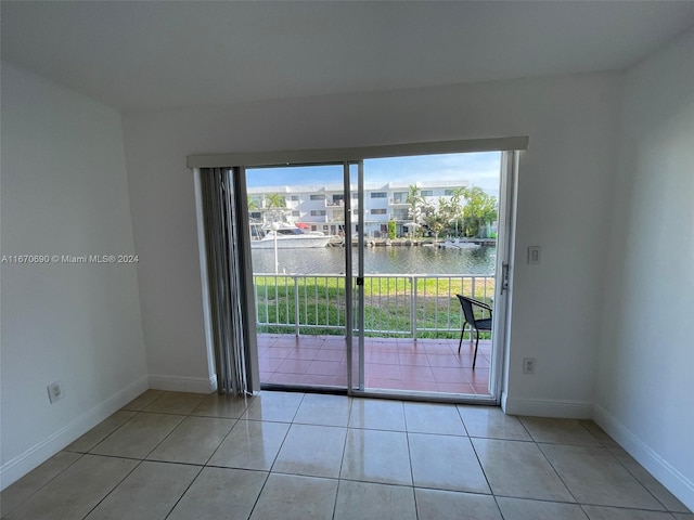 tiled spare room with a water view