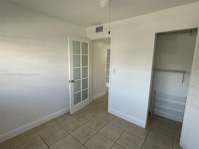 unfurnished bedroom featuring light tile patterned floors and a closet