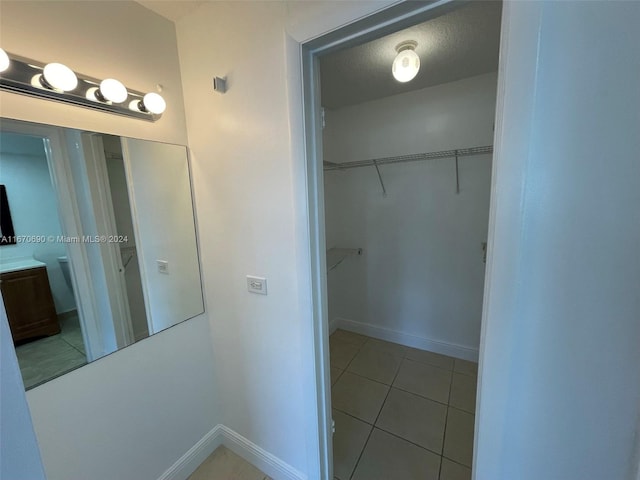 bathroom with tile patterned flooring, vanity, and a textured ceiling