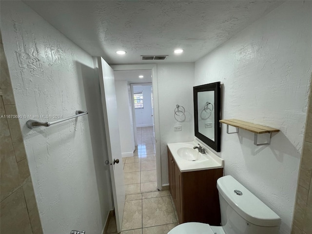 bathroom with vanity, a textured ceiling, tile patterned floors, and toilet