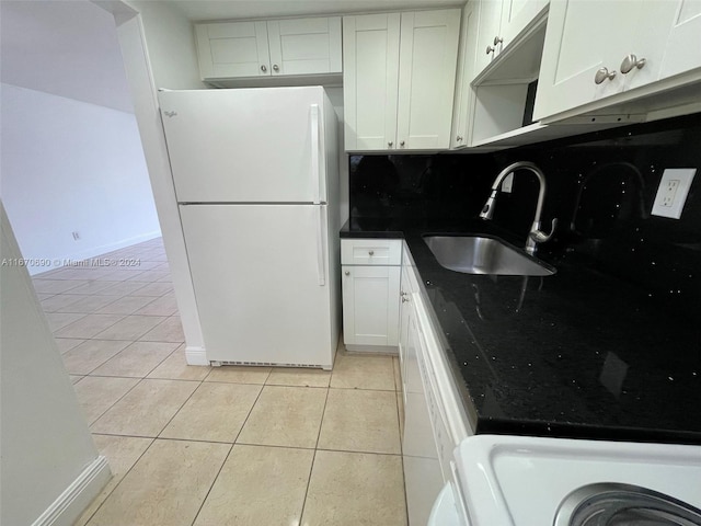 kitchen featuring decorative backsplash, sink, light tile patterned floors, white refrigerator, and white cabinetry