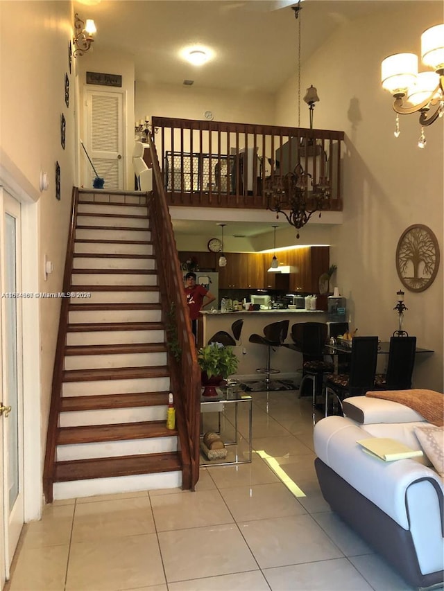 staircase featuring tile patterned flooring and a chandelier