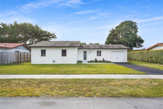 ranch-style house with a garage and a front lawn