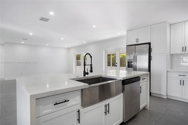 kitchen featuring decorative backsplash, white cabinetry, sink, and appliances with stainless steel finishes