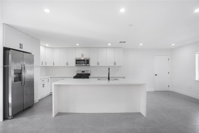 kitchen featuring white cabinetry, a kitchen island with sink, sink, and appliances with stainless steel finishes