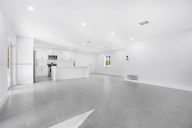 unfurnished living room with light tile patterned floors and sink