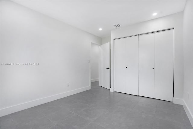 unfurnished bedroom featuring tile patterned flooring and a closet