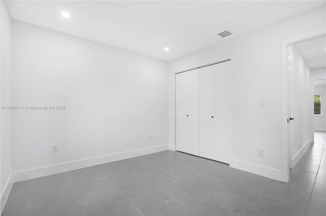 unfurnished bedroom with tile patterned flooring and a closet