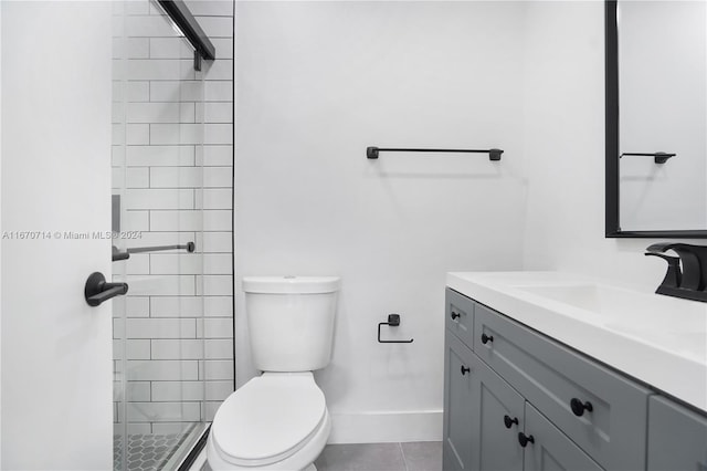 bathroom with tile patterned floors, vanity, toilet, and tiled shower