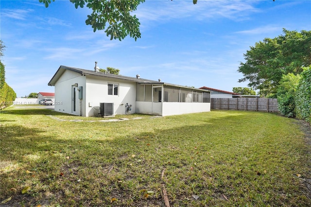 back of property with a sunroom and a yard