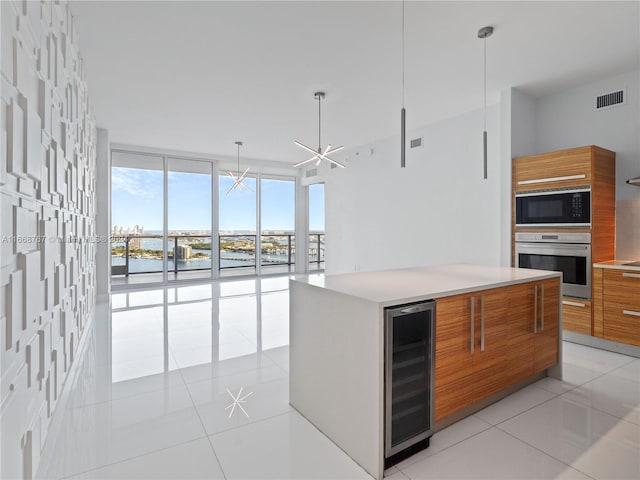 kitchen with stainless steel oven, wine cooler, light tile patterned floors, black microwave, and a chandelier