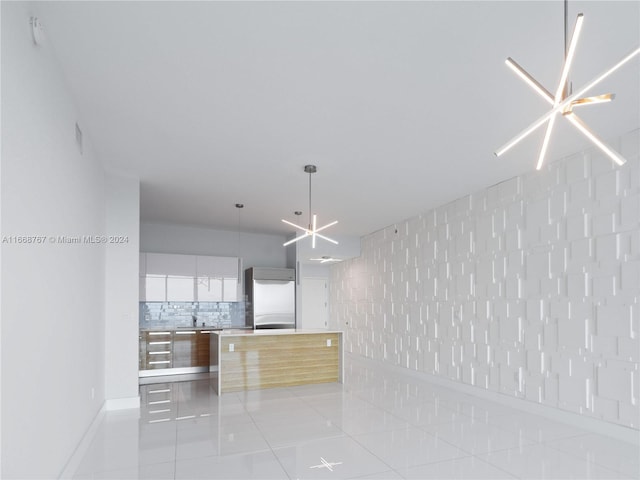 interior space featuring white cabinetry, built in refrigerator, light tile patterned floors, and a notable chandelier