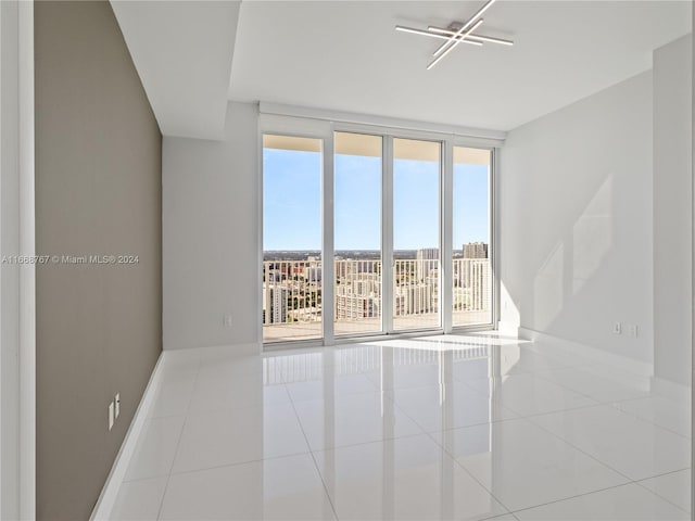 spare room featuring floor to ceiling windows, a wealth of natural light, and light tile patterned floors