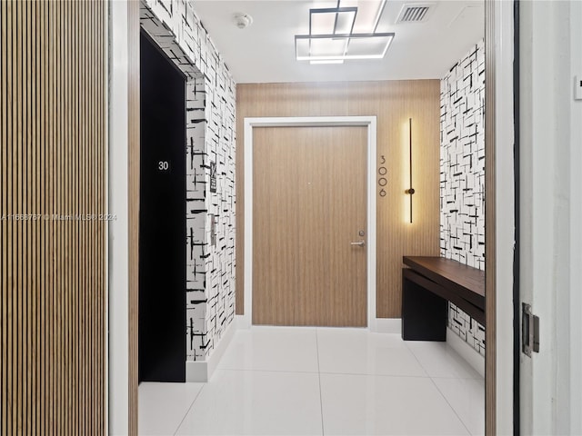 interior space with wooden walls and light tile patterned floors