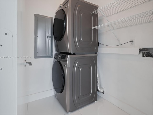 laundry room featuring stacked washer / dryer and electric panel