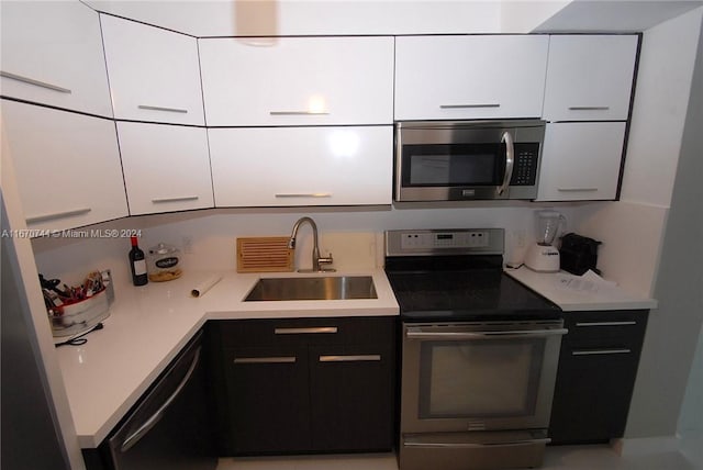 kitchen with white cabinets, appliances with stainless steel finishes, and sink