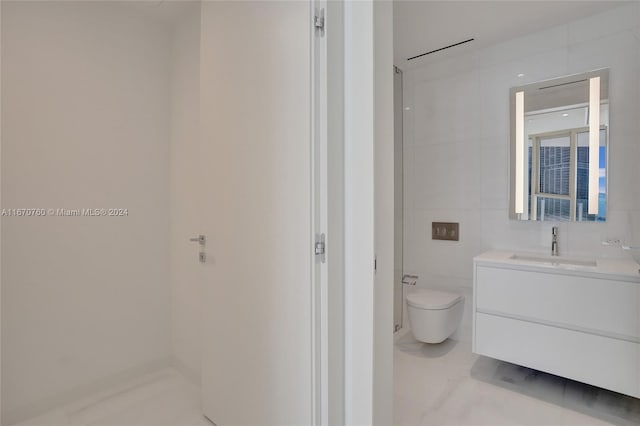 bathroom with tile walls, vanity, and toilet