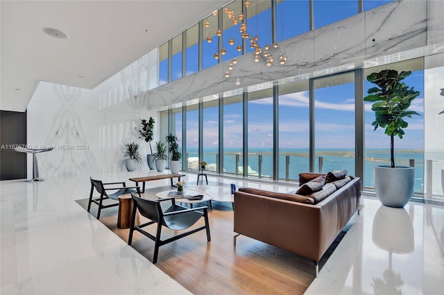 living room featuring a wall of windows, a water view, hardwood / wood-style floors, and plenty of natural light