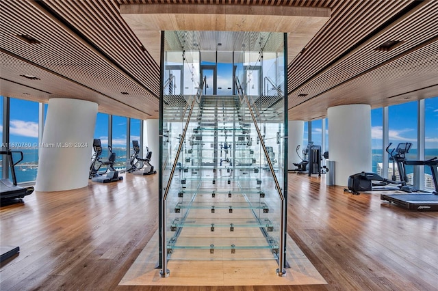 stairs featuring a wall of windows and hardwood / wood-style flooring