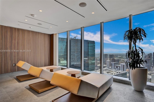 living room featuring a wall of windows and wood walls