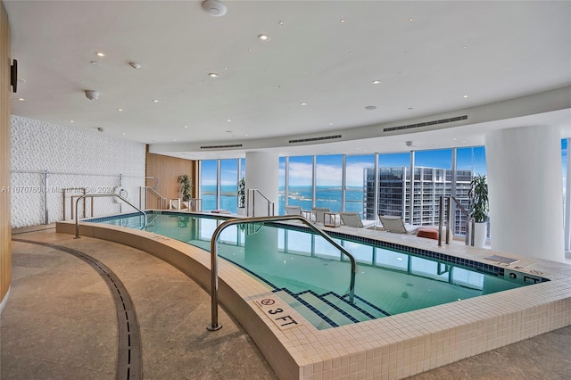 view of pool featuring a hot tub and a water view