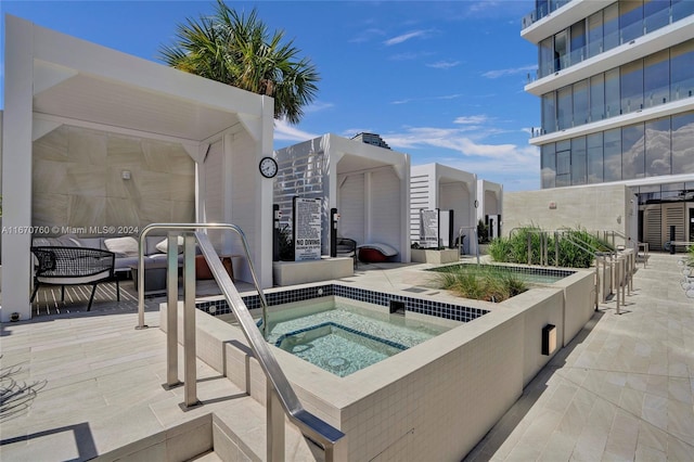 view of swimming pool with a patio area and a hot tub