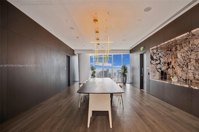 dining room featuring crown molding, an inviting chandelier, dark wood-type flooring, and expansive windows