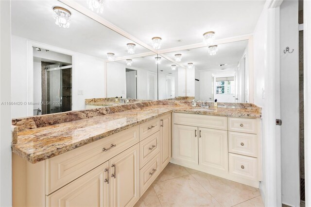 bathroom with tile patterned flooring, vanity, and a shower with door