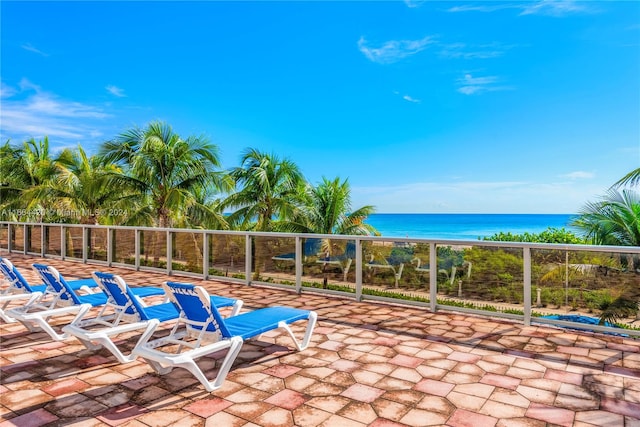 view of patio featuring a water view and a beach view